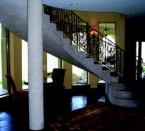 This home adds light to the lower level with a curved wall using the removable concrete forming wall system. The poured-in-place steel-reinforced concrete staircase and the support columns are finished with an ivory-colored plaster coat. The mix is masonry cement and sand with polymer additives. The sand-to-cement ratio creates a suede-like texture. The concrete floor has chemical stain to finish.