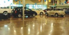 A polished concrete floor reflects the shine off vehicles at an auto dealer.