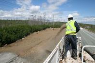 A crewmember applies the biotic-enriched hydraulic growth medium along highly erodible, sandy roadside soil in northern Québec.