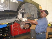 Dekalb Fleet Management technician installing front struts on a county police vehicle.