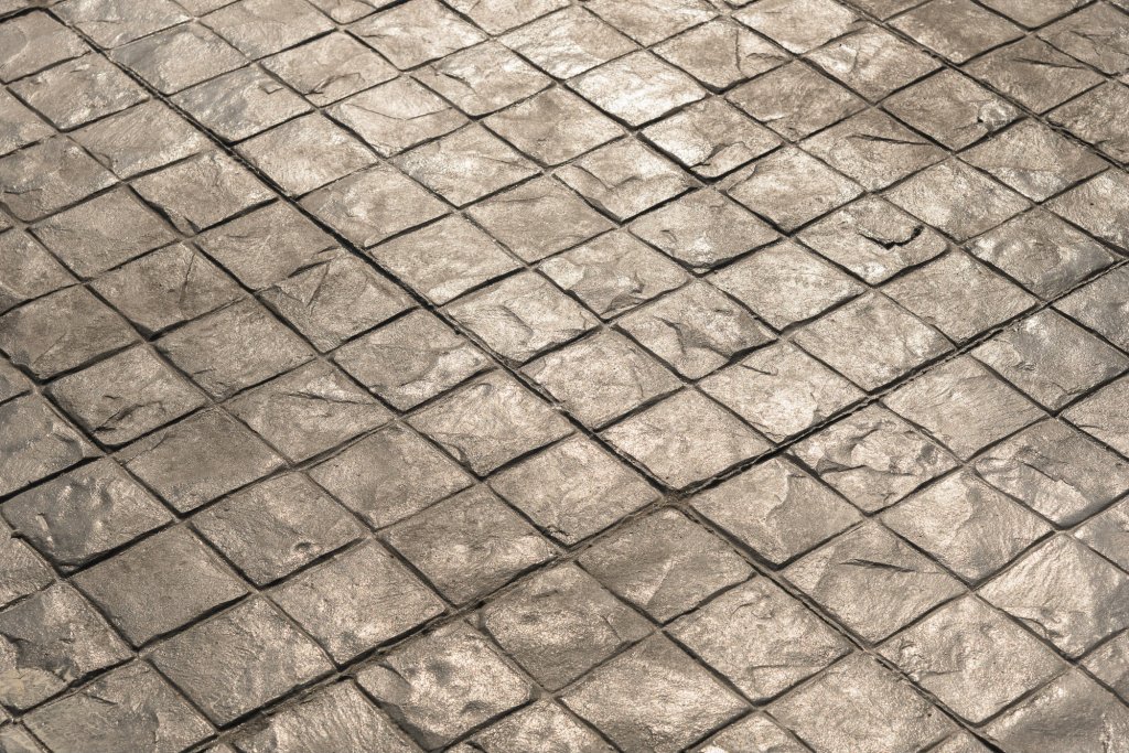 Avoid a straight construction joint where sections meet by carving off excess material at the stamp pattern’s edge with a margin trowel or scraper. When you tie in the next placement to this joint, hand trowel the overlay gently against it and continue the pattern. Done properly, you’ll get a seamless transition.