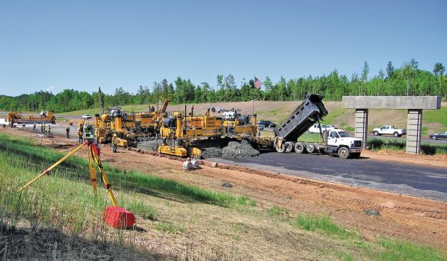 The robotic total station shown here provides steering and elevation control for the placer and slipform paver.