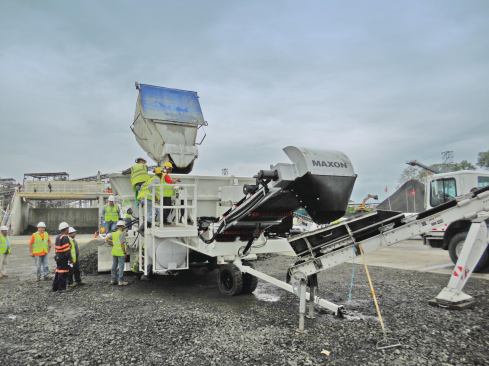 Agitator trucks dump concrete into the hopper, which provides a steady feed to the conveyors. 