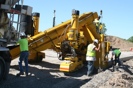 Concrete placed into the conveyor is fed into the slipform mold.