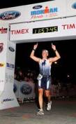 Jimmy Sobeck Jr. crosses the finish line at the Ironman Triathlon in Panama City, Fla.