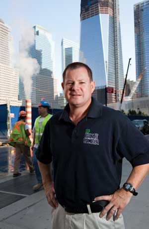 Kurtz stands in front of 1 World Trade Center, the skyscraper being constructed on the site of the former World Trade Center.