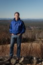 Kevin Hancock, president of Hancock Lumber. Behind him is his company’s sawmill in Casco, Maine, and company land with stands of Eastern White Pines.