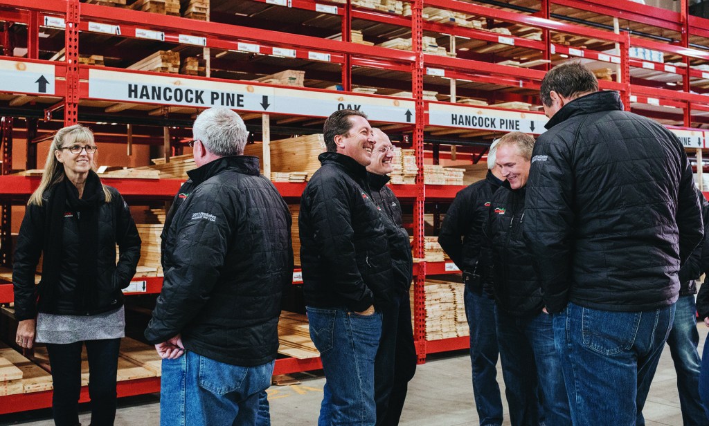 Senior members of the Hancock Lumber team chat as they get ready for a group shot