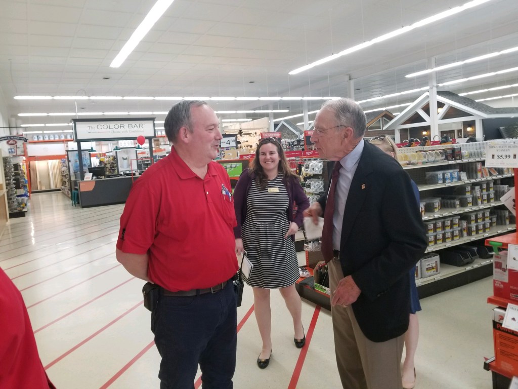 Tom Leavitt of Marcus (Iowa) Lumber chats with Sen. Chuck Grassley, R-Iowa, during the senator's visit to Marcus on May 30, 2018. In the background is legislative aide Jennifer Heins