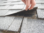 Shingle nailing. Shingles must be nailed at the ends, which did not happen in the roof pictured.