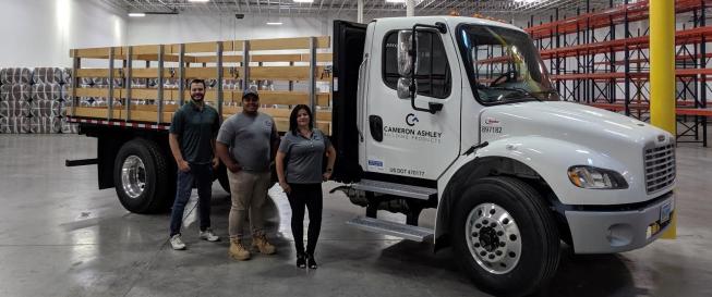 DC Manager, Tanner Davis, Warehouse Specialist Cristian Alvarez, and TSM Clara Blake pose with one of their new trucks