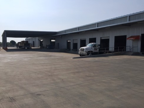 The warehouse includes multiple docks at truck and pickup truck height, along with a covered receiving area for all-weather operations.