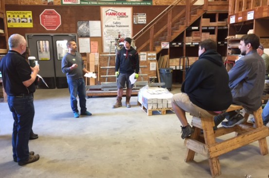 A team huddle at Hancock Lumber