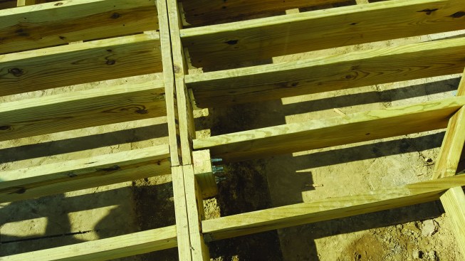 The new deck was built over an old concrete patio. At the bottom of the photo, you can see one of the holes that were cut through the slab in order for us to dig down below frost level and install a proper footing.