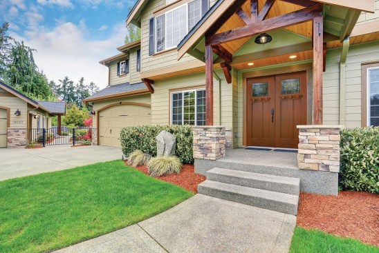 Luxurious home with well kept lawn, and green exterior paint.