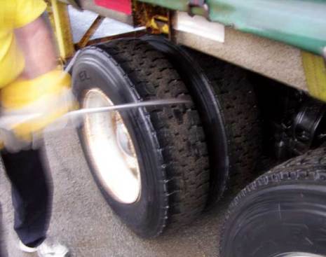 Almaas uses a metal bar to give each tire a light thump. It helps him detect whether the tire is underinflated or could have tread problems.