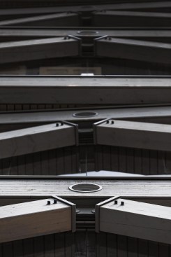 Steel caps the tops of glulam web members to reduce the risk of moisture infiltration