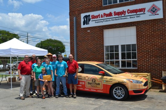 Members of the Short & Paulk team pose with the car that the dealer gave away as part of its 75th anniversary marketing campaign.