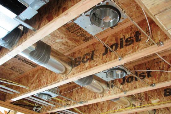 Running ducts through joists rather than above or below the home's conditioned air spaces reduces the load on heaters and coolers.